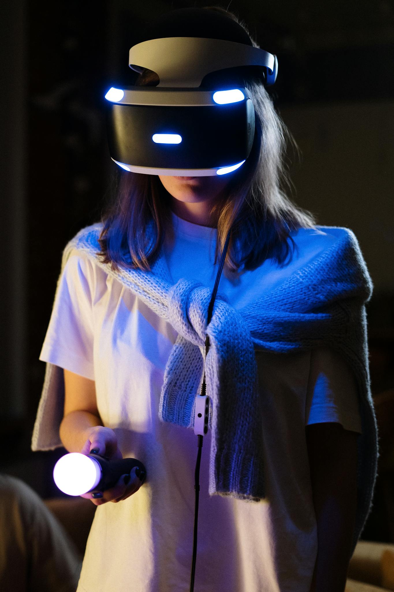 A young woman immersed in virtual reality gaming, wearing a VR headset and controller.